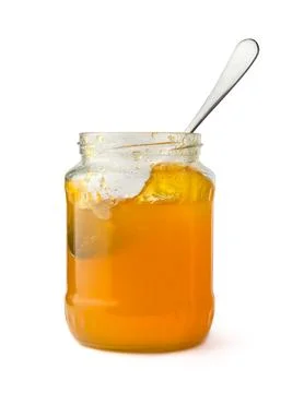 Fruit jam bottle with a spoon, isolated on white Stock Photos