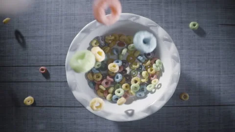 Fruit Loops cereal breakfast falls into bowl w/ milk being poured in slow motion Stock Footage 154217741