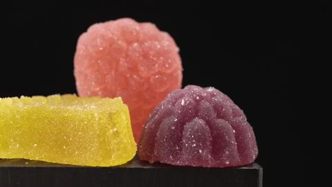 Fruit multicolored marmalade sprinkled with sugar, close-up on a black backgroun Stock Footage 137162251