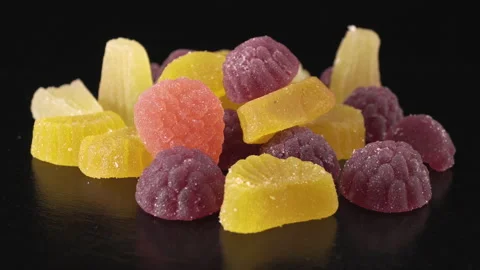 Fruit multicolored marmalade sprinkled with sugar, close-up on a black backgroun Vídeos de archivo 137238909