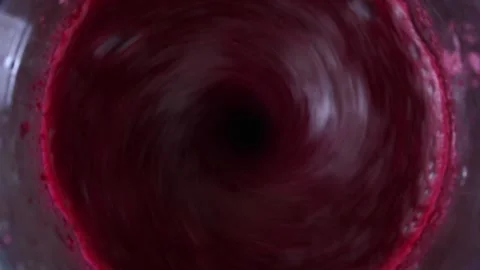 Fruit or vegetable red burgundy juice is spinning in a blender. Smoothie making Stock Footage 234685346