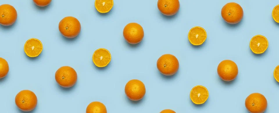 Fruit pattern, creative summer concept. Fresh juicy whole and sliced orange Stock Photos