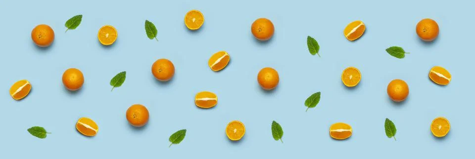 Fruit pattern, creative summer concept. Fresh juicy whole and sliced orange Stock Photos