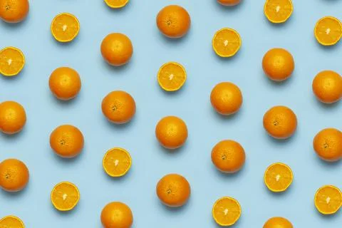 Fruit pattern, creative summer concept. Fresh juicy whole and sliced orange Stock Photos