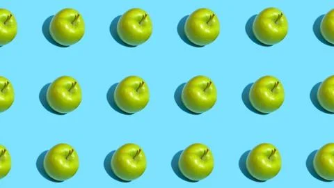 Fruit pattern of fresh green apples on blue background. Top view. Summer conc Stock Photos