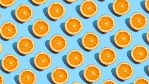 Fruit pattern of fresh orange slices on blue background. Top view. Summer con Stock Photos