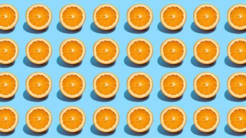Fruit pattern of fresh orange slices on blue background. Top view. Summer con Foto stock