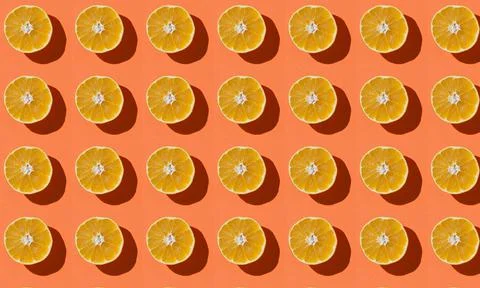Fruit pattern of fresh orange slices on an orange background Stock Photos