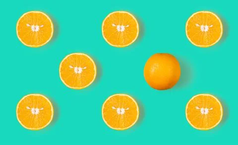 Fruit pattern of fresh orange slices and a whole orange on a blue background Stock Photos