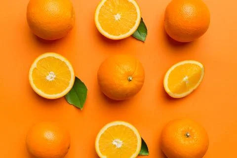 Fruit pattern of fresh orange slices on colored background. Top view. Copy Sp Stock Photos