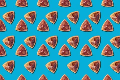 Fruit pattern of red orange slices on blue background Stock Photos