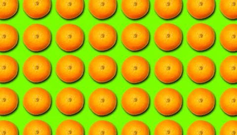 Fruit pattern of ripe oranges with a shadow on a green background. Foto stock