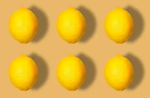 Fruit pattern of whole lemons with shadow on a beige background. Stock Photos