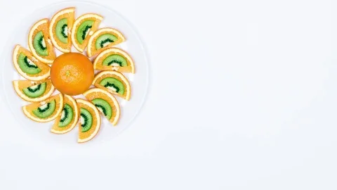 Fruit Plate Roll. Stop Motion Animation With Orange Fruit and Kiwi on a White Video stock 74102403