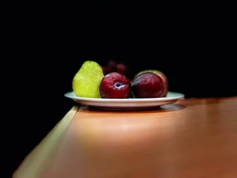 Fruit plate on the table with a black background. Stock Photos