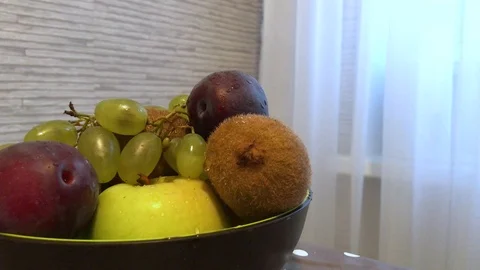 Fruit in a plate on the table. drops of water on the fruit. 1 Stock Footage 98048033