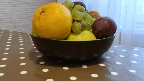 Fruit in a plate on the table. I put the fruit in the bowl. 13 Stock-Footage 98047908