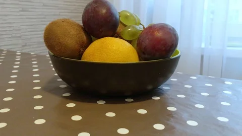 Fruit in a plate on the table. I put the fruit in the bowl. 12 Stock Footage 98047912