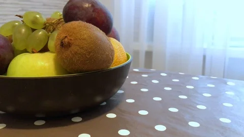 Fruit in a plate on the table. I put the fruit in the bowl. 10 Video stock 98047929