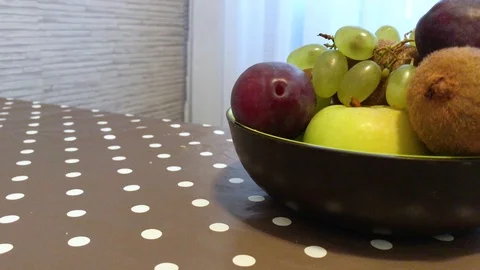 Fruit in a plate on the table. I put the fruit in the bowl. 9 Stock Footage 98047930