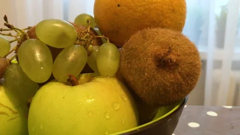 Fruit in a plate on the table. I put the fruit in the bowl. 1 Stock Footage 98048012