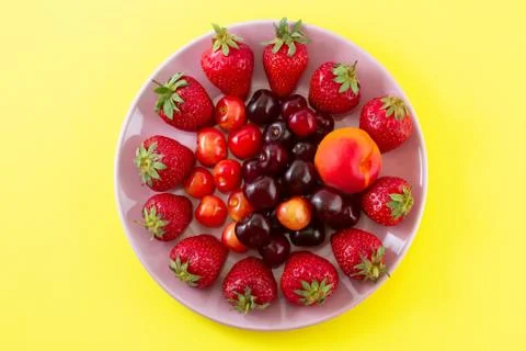 Fruit on a plate on a yellow background. Stock Photos