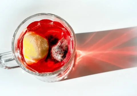 Fruit red tea with lemon, raspberry tea in a large transparent glass cup. R.. Stock Photos