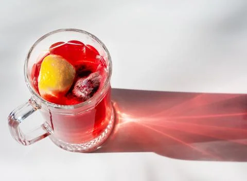 Fruit red tea with lemon, raspberry tea in a large transparent glass cup. R.. Stock Photos
