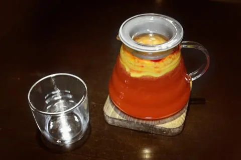 Fruit red tea in a transparent teapot with a glass Stock Photos