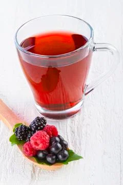 Fruit red tea with wild berries in wooden spoon Stock Photos