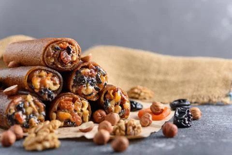 Fruit roll-up with nuts, prunes, dried apricots and honey, vegetarian snack,  Stock Photos