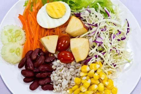 Fruit salad with boiled egg on a white plate Stock Photos
