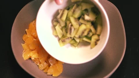 Fruit salad with kiwi, oranges, pineapple, blueberries, grapes, and pomegranate Stock Footage 344866742