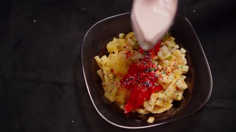 Fruit salad is poured with strawberry yogurt. Stock Footage