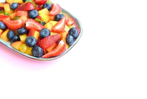 Fruit salad in a rectangular plate on a white background. Sliced strawberries Foto stock
