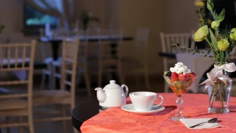 Fruit salad, tea pot, tea cup, flowers on restaurant table Stock Footage 127855405