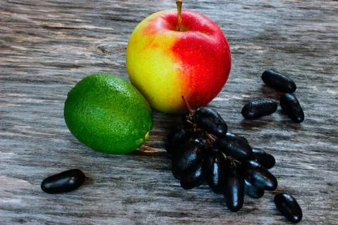 Fruit set. fresh lime, apple and grapes on a wooden surface. Stock Photos