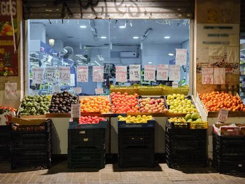 Fruit shop with boxes full of fruit outside at night Stock Photos