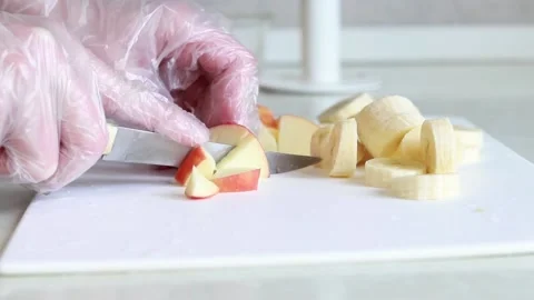 Fruit slicing, close up. Cut apples and bananas on a kitchen board Stock Footage 236423464