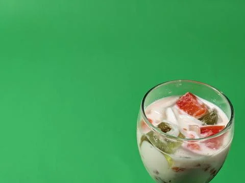 Fruit soup or mixed ice in a glass cup on a green background Stock Photos