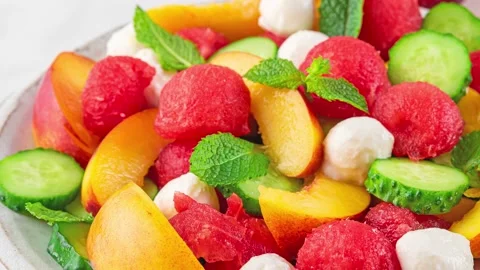 Fruit summer salad made of fresh fruits, mozzarella cheese, cucumbers and mint Stock Footage 239979642