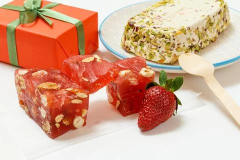 Fruit sweets with nuts and gift box on white background. Stock Photos