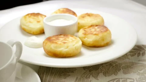 Fruit tea is being poured into a cup with cheesecakes in background. Slow mo. HD 動画素材 107434883