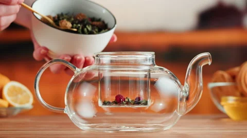 Fruit tea ceremony process. Putting dry tea leaves into teapot on a wooden table Stock Footage 190896127