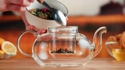 Fruit tea ceremony process. Putting dry tea leaves into teapot on a wooden table Stock-Footage 192399104