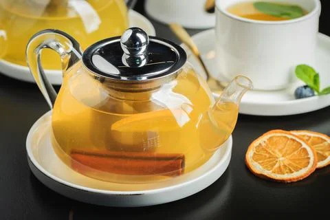 Fruit tea with mango and mint in a glass teapot on the table Stock Photos