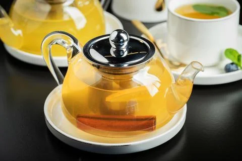 Fruit tea with mango and mint in a glass teapot on the table Stock-Fotos
