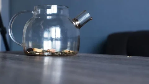 Fruit tea with various ingredients is poured into the teapot with a spoon. Stock Footage 304160934