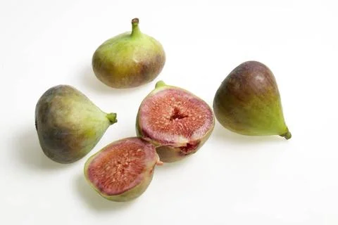 Fruit , Three full one cut Figs Ficus Anjir , fleshy sweet pear shaped yel... Stock Photos