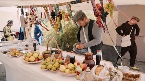 A fruit vendor in the bazaar wipes an apple on his clothes Stock Footage 248690625